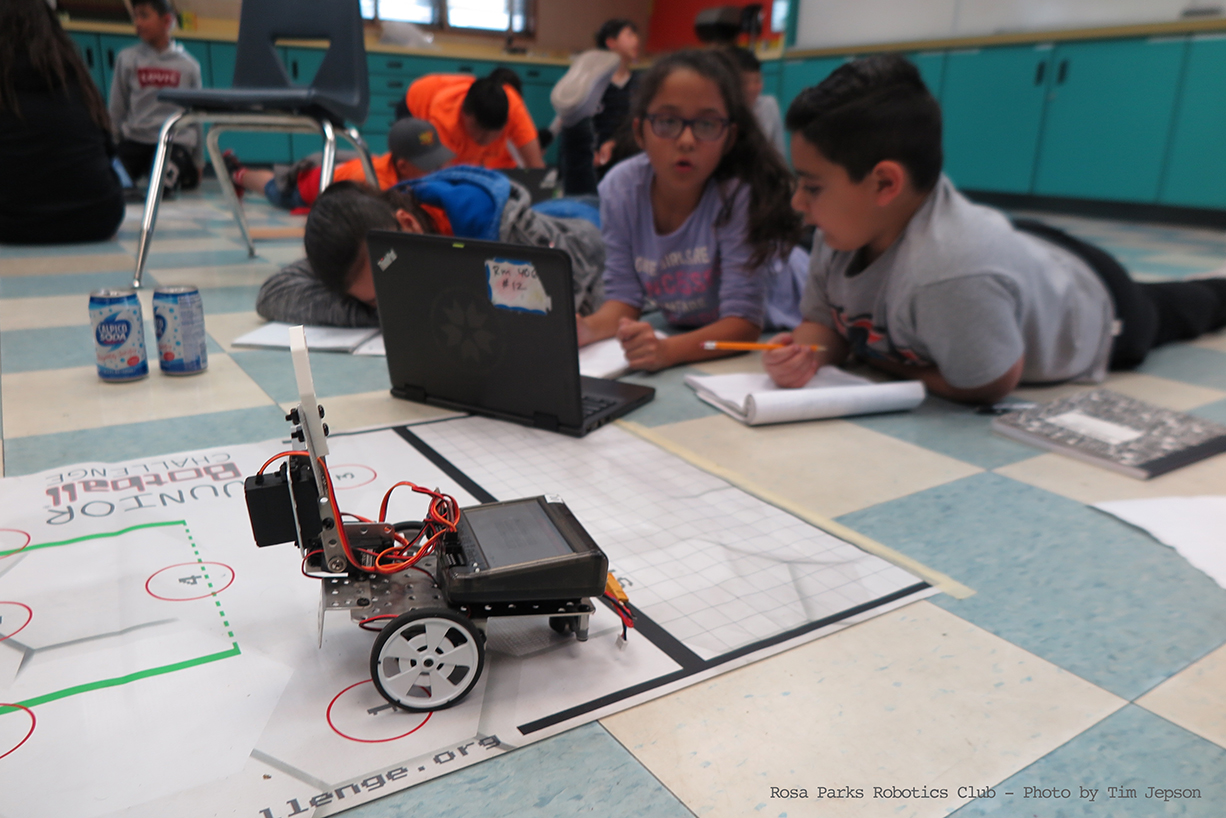 Robotics Club students programing an educational robot.